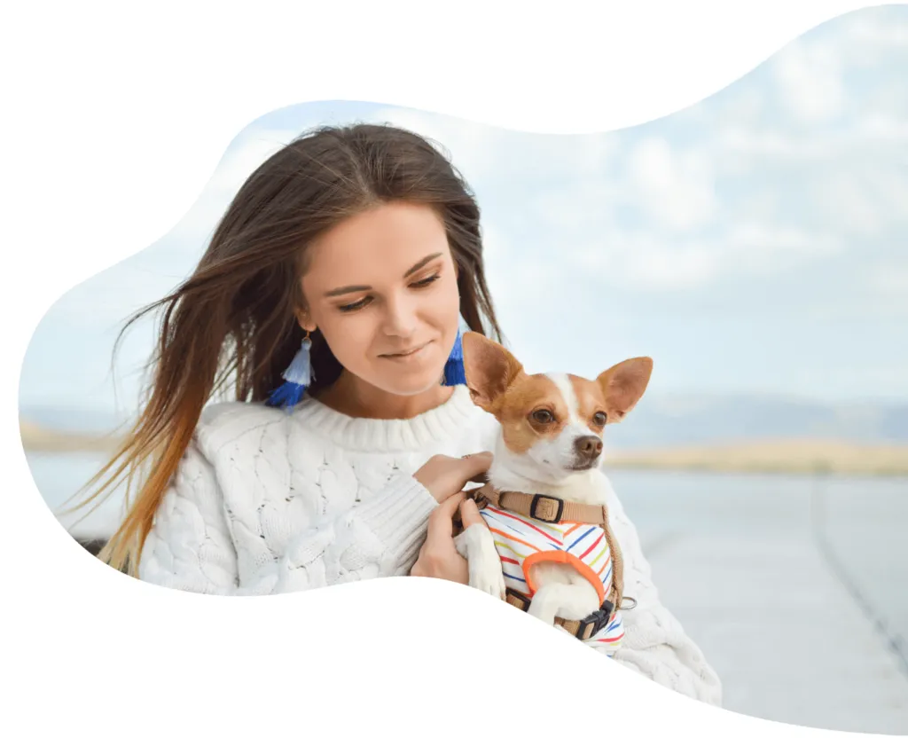 junge Frau hält einen kleinen Hund auf dem Arm